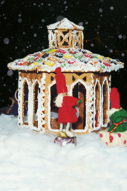 Foto av pepparkakshus i form av en gammal punschpaviljong, omringad av tomtar