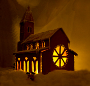 Foto av pepparkakskyrkan i mörker, då den är upplyst inifrån